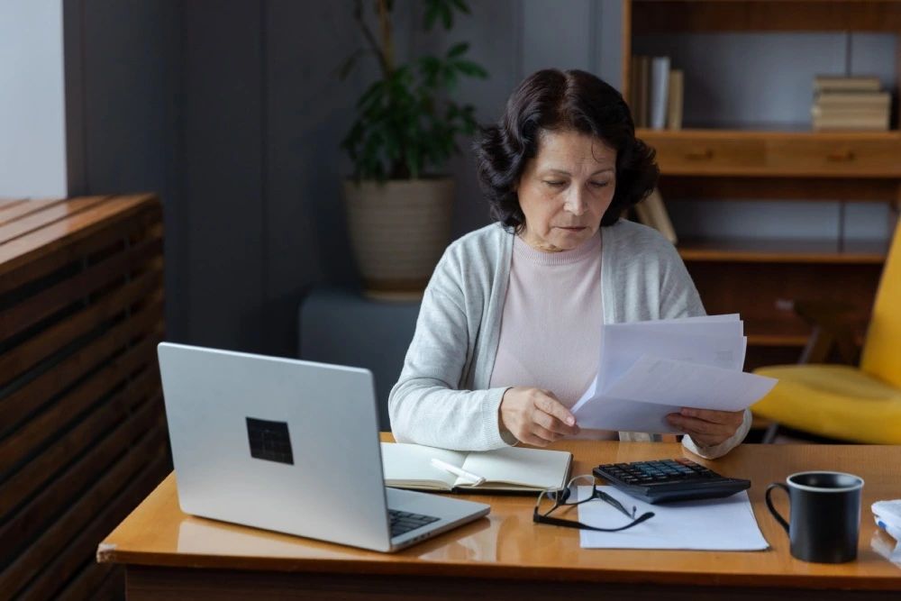 Adulta mayor revisando documentos con tranquilidad